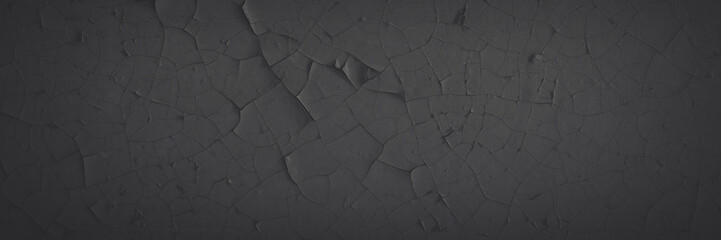 Dark wide panoramic background. Peeling paint on a concrete wall. Faded dark texture of old cracked flaking paint. Weathered rough painted surface with patterns of cracks. Shaded background for design