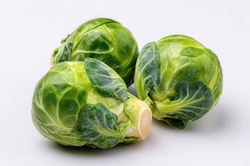 Fototapeta premium Three Brussels Sprouts on White Background - Close-up Food Photography, Green Vegetable, Healthy Eating Concept
