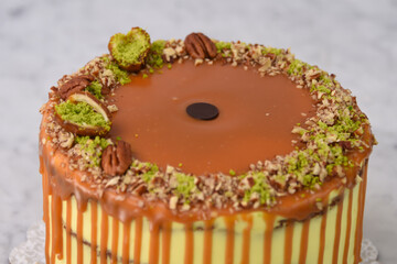 Pistachio Caramel Drip Cake featuring layers of moist cake drizzled with rich caramel, topped with...
