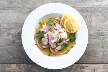 Traditional Peruvian ceviche sea bass fillet on wooden table. Top view