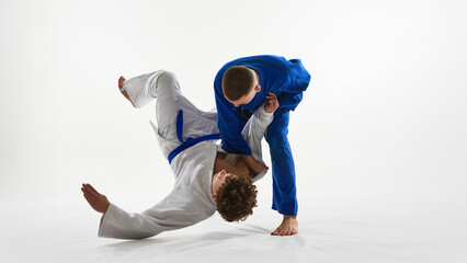 Decisive hip throw unfolding, white gi athlete launches opponent in controlled arc, embodying skill...
