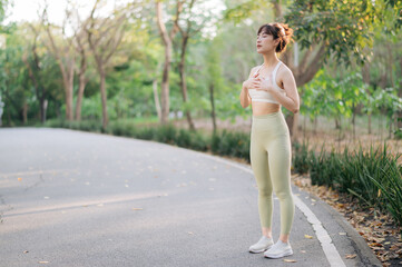 Asian woman outdoor workout, healthy and active lifestyle concept. She is standing on park pathway,...