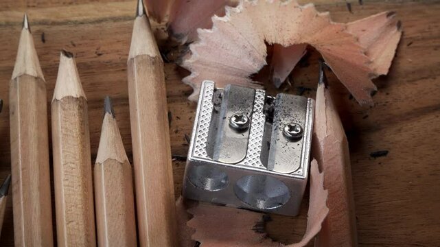 Pencil sharpener shavings and plain pencils close up stock footage