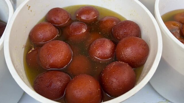 Gulab Jamun, a Bengali sweet dish served in white container.
