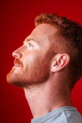 Obraz premium Red solid background. Idea of style for aging men. Trendy men's textured crop haircut - midlife white man with red hair. A fashionable midlife male standing confidently.