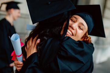 Two happy students hugging at graduation ceremony