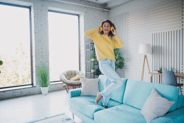 Woman enjoying music indoors wearing headphones in a modern bright living room