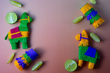 Handmade llama piñatas crafted from fringed paper, arranged playfully against a brown background...