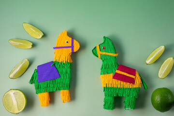Handmade llama piñatas crafted from fringed paper, arranged playfully against a green background...