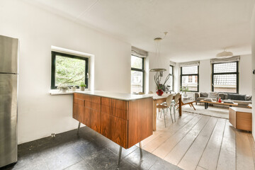 Stylish apartment interior featuring wooden furniture, large windows, and a bright, open layout that emphasizes natural light and contemporary design.