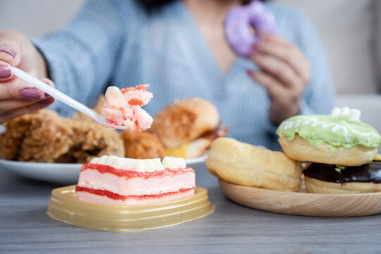 woman dealing with binge eating disorder, eat a lot of fast food like burgers, fried chicken, donuts, and desserts, showing unhealthy eating habits and emotional stress related to food