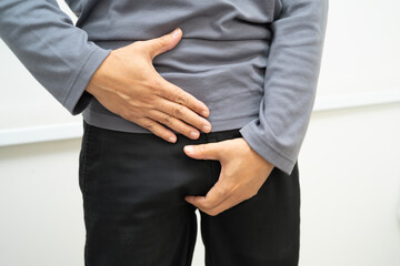 Hernia, Asian man stomach ache, abdominal pain and urology problem health.