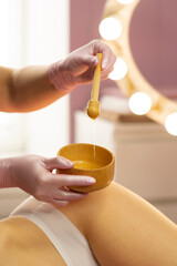 Therapist preparing honey mixture during beauty body treatment. Honey detox massage or caramel liposuction