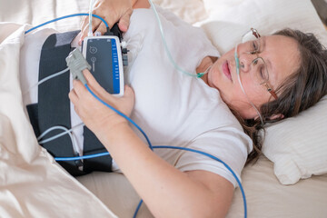 Woman wearing portable sleep tracker on abdomen, Female patient with sleep and health monitoring...