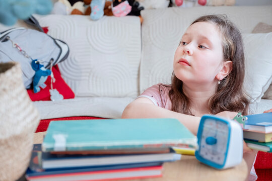 Caucasian Girl Doing Homework at Desk in Cozy Children's Room with Emotional Expression
