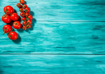 cherry tomatoes on blue wood top view. with space for text.