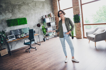 Asian female programmer showcasing a well-organized modern workspace with computers and green...