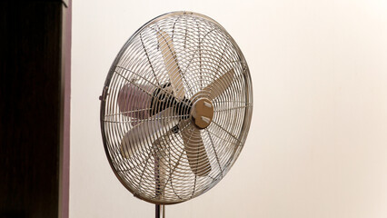 Household home fan on white wall background in room.