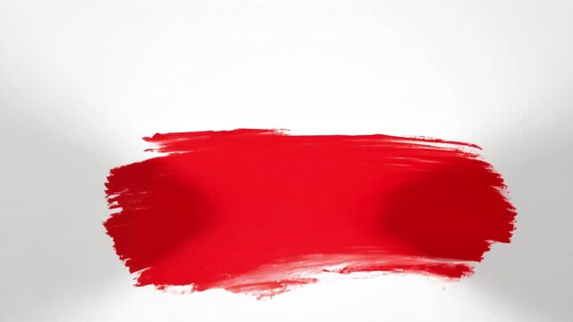 Red paint stroke being applied across white background. The brushstroke starts thin on the left, expands to full width in the middle, and gradually tapers off to the right, creating artistic movement.