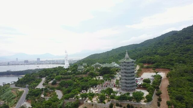 Aerial view featuring the Thap Xa Loi Temple and the prominent white statue of Linh Ung Pagoda in the Da Nang region of Vietnam, showcasing Buddhist architecture and the coastal cityscape.