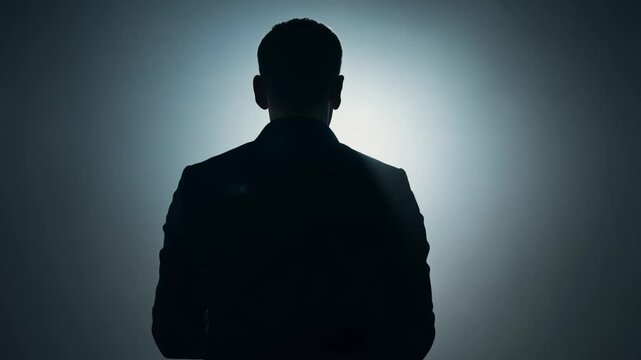 Businessman silhouette facing bright light in six shots