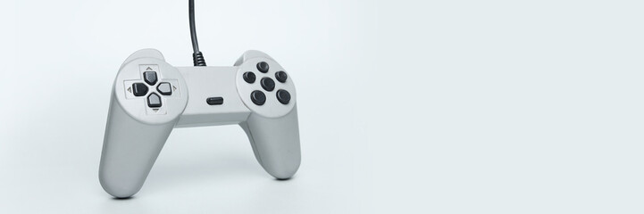 Close-up of retro wired video game controller against pale background symbolizing classic gaming...