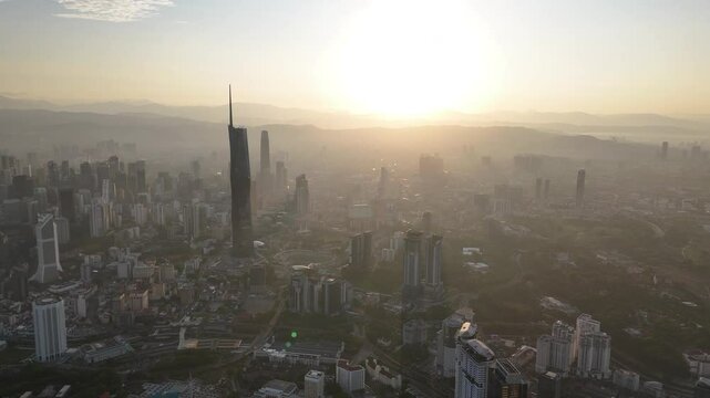 Aerial view cinematic establishing shoot of Kuala Lumpur city center view at sunrise dawn overlooking the city skyline in Federal Territory, Malaysia