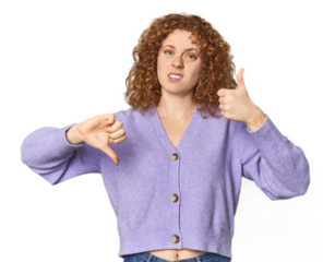 Young Caucasian redhead woman showing thumbs up and thumbs down, difficult choose concept