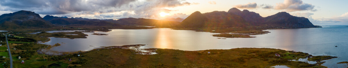 Aerial panoramic view of scenic sunset over lake and mountains in Lofoten Islands, Norway

