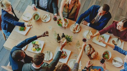 A diverse group of men and women celebrating at a dining table. The joyful gathering features toasts with drinks, delicious food, and a warm atmosphere, showcasing unity and friendship.
