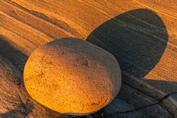 Unique coastal rock formation under warm light in Sweden highlights natural beauty and textures during golden hour