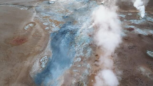 Overhead image of steaming hydrothermal vents and bubbling mud pools at Hverir, surrounded by vivid mineral sediments in North Iceland.