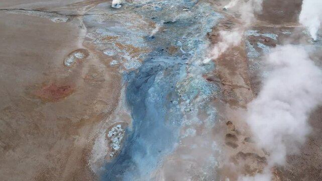 Drone view over cracked volcanic terrain and steaming mud pools in Hverir, showing intense geothermal activity near Lake Myvatn.