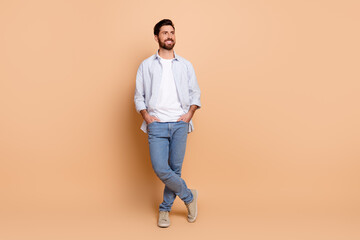 Young fashionable man posing with charisma on neutral background showcasing casual wear and...