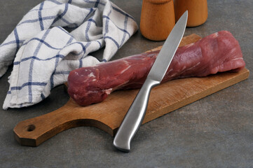 Filet mignon cru sur une planche à découper avec un couteau en gros plan