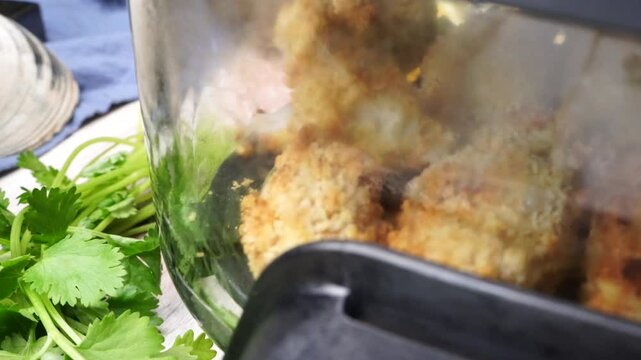Using an air fryer to make homemade fish sticks for a quick and easy dinner,  Breaded fish sticks being cooked in an air fryer.  Easy seafood dinner meal.