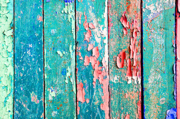 Turquoise and pink peeling paint on the wooden surface, peeling paint texture background