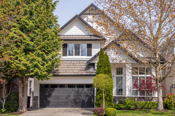 Two story stucco luxury house with nice spring blossom landscape in Vancouver, Canada, North America. Day time on April 2025.