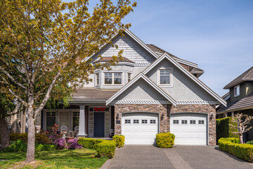 Two story stucco luxury house with nice spring blossom landscape in Vancouver, Canada, North America. Day time on April 2025.