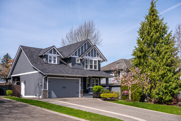 Two story stucco luxury house with nice spring blossom landscape in Vancouver, Canada, North...