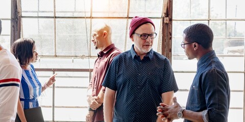 Diverse group in casual attire socializing in a modern loft for new community and connection. Diverse group communicating and networking in a bright for new community and connection.