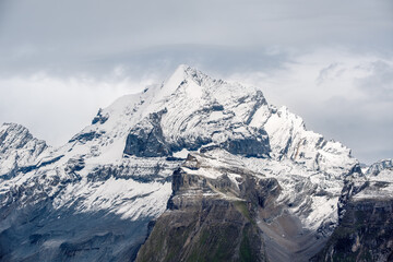 A mountain covered in snow under a cloudy sky. Doldenhorn 3638 m. is a high mountain of the Bernese Alps in Switzerland.
