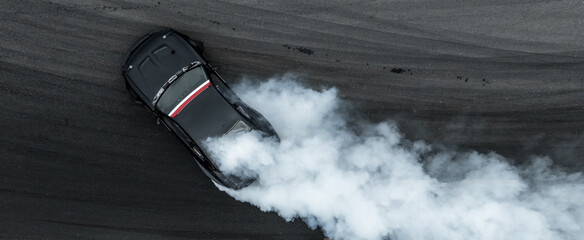 Aerial view car drift on asphalt race track with lot of smoke from burning wheel tires rubber,...