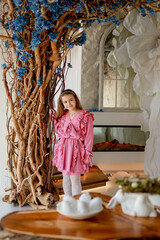 Cute girl in pink dress. Modern interior. Easter holiday