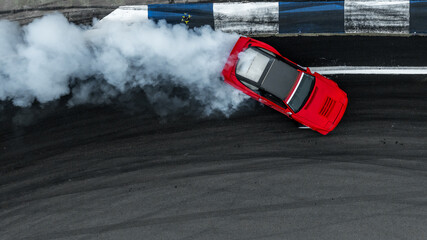 Aerial view car drift on asphalt race track with lot of smoke from burning wheel tires rubber, Drift motorsport car drift race, Professional driver drift car on asphalt race track, Car motion blurred