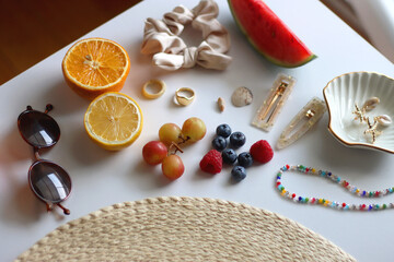 Straw hat, sunglasses, seasonal fruit, seashells and colorful accessories on white backgrounds. Cute summer essentials. Selective focus.