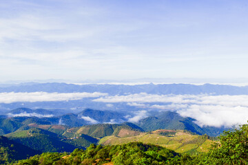 Obraz premium Scenic Mountain Landscape with Blue Sky and Layers of Misty Hills