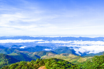 Naklejka premium Scenic Mountain Landscape with Blue Sky and Layers of Misty Hills