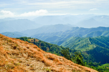 Fototapeta premium Scenic Mountain Landscape with Blue Sky and Layers of Misty Hills