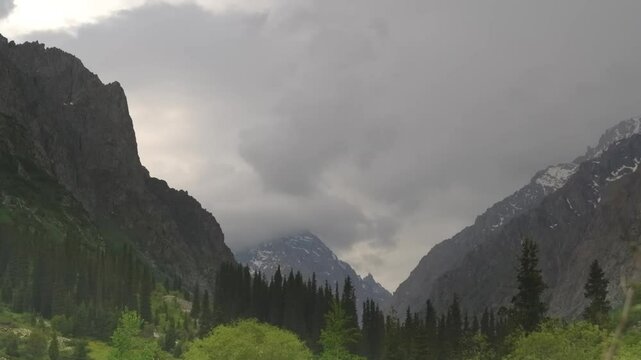 Dynamic time-lapse aerial footage capturing the rugged peaks, forests, and changing clouds of Ala Archa National Park near Bishkek, Kyrgyzstan.